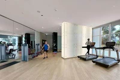 a gym with two people running on treadles in a room at ALiving Stylish Studio with Balcony I Partial Burj Khalifa View I DAMAC Maison Prive B-1315 in Dubai