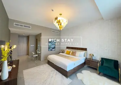 a bedroom with a large bed and a chandelier at Grande 3BR in Stella Maris, Sea View, Dubai Marina in Dubai