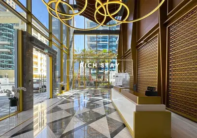 a lobby of a high rise building with a chandelier at Grande 3BR in Stella Maris, Sea View, Dubai Marina in Dubai