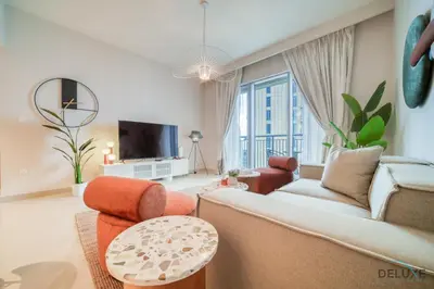 a living room with a couch and a tv at Classic 1BR at Harbour Views Tower 1 by Deluxe Holiday Homes in Dubai