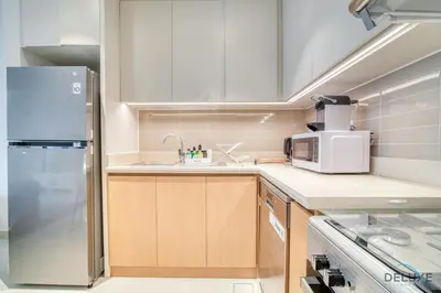 a kitchen with a sink and a refrigerator at Classic 1BR at Harbour Views Tower 1 by Deluxe Holiday Homes in Dubai