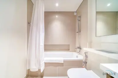 a bathroom with a tub and a toilet and a sink at Classic 1BR at Harbour Views Tower 1 by Deluxe Holiday Homes in Dubai