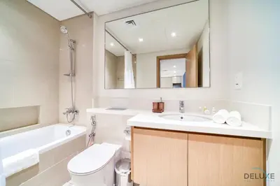 a bathroom with a toilet and a sink and a mirror at Classic 1BR at Harbour Views Tower 1 by Deluxe Holiday Homes in Dubai