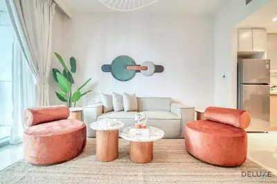 a living room with two chairs and a table at Classic 1BR at Harbour Views Tower 1 by Deluxe Holiday Homes in Dubai