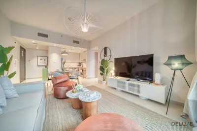 a living room with a couch and a tv at Elegant 1BR at Harbour Views Tower 1 by Deluxe Holiday Homes in Dubai