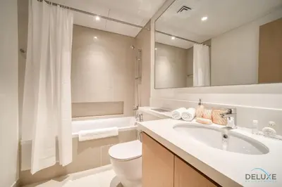 a bathroom with a sink and a toilet and a tub at Elegant 1BR at Harbour Views Tower 1 by Deluxe Holiday Homes in Dubai