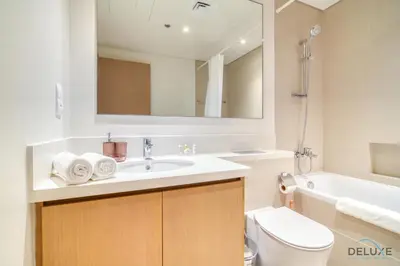 a bathroom with a sink and a toilet and a mirror at Alluring 1BR at Harbour Views Tower 1 by Deluxe Holiday Homes in Dubai