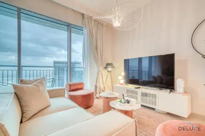 a living room with a couch and a large window at Alluring 1BR at Harbour Views Tower 1 by Deluxe Holiday Homes in Dubai