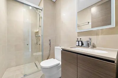a bathroom with a toilet and a sink and a shower at Perfect 1 BR for Family Stay - Close to Downtown in Dubai