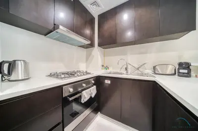 a kitchen with a sink and a stove top oven at Soothing 1BR at Merano Business Bay by Deluxe Holiday Homes in Dubai