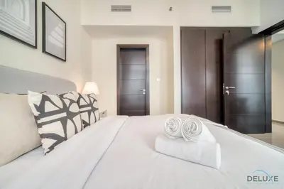 a bedroom with a large white bed with two towels at Soothing 1BR at Merano Business Bay by Deluxe Holiday Homes in Dubai
