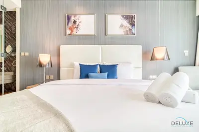 a bedroom with a large white bed with blue pillows at Polished 3BR at DAMAC Towers by Paramount A Business Bay by Deluxe Holiday Homes in Dubai