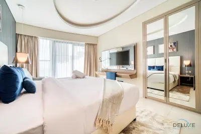 a bedroom with a large white bed and a large mirror at Polished 3BR at DAMAC Towers by Paramount A Business Bay by Deluxe Holiday Homes in Dubai