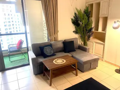 a living room with a couch and a coffee table at Charming spacious studio apartment in the heart of JBR By SWEET HOMES in Dubai