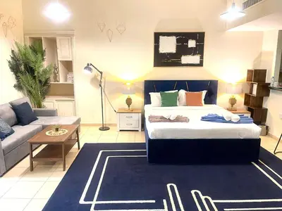 a living room with a bed and a couch at Charming spacious studio apartment in the heart of JBR By SWEET HOMES in Dubai