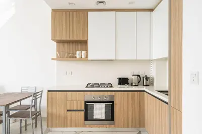 a kitchen with white cabinets and a table and a stove at Luxurious 1-bedroom apartment in Dubai Hills in Dubai