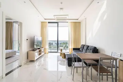 a living room with a table and a couch at Luxurious 1-bedroom apartment in Dubai Hills in Dubai