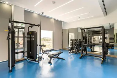 a gym with several treadmills and machines at Luxurious 1-bedroom apartment in Dubai Hills in Dubai