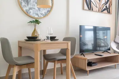 a dining room table with a television and two chairs at Lovely Studio & Budget Friendly in Dubai