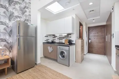 a kitchen with a stainless steel refrigerator and a washer at Lovely Studio & Budget Friendly in Dubai
