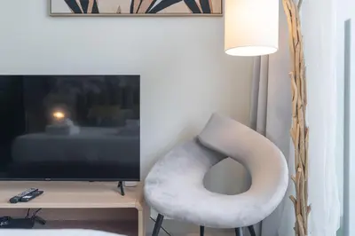 a white chair sitting in front of a television at Lovely Studio & Budget Friendly in Dubai