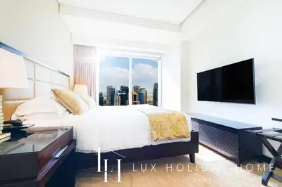 a bedroom with a large bed and a large window at LUX The JW Marina Suite in Dubai