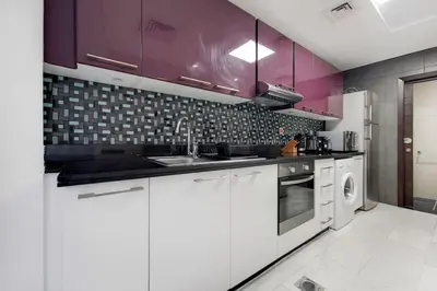 a kitchen with white appliances and purple cabinets at Cayan Tower, Dubai Marina - Charming One Bedroom in Dubai