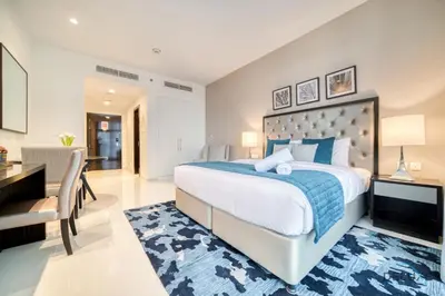 a bedroom with a large bed and a desk and a chair at Lively Studio at DAMAC Celestia A Dubai South by Deluxe Holiday Homes in Dubai