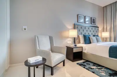 a bedroom with a king sized bed and a chair at Lively Studio at DAMAC Celestia A Dubai South by Deluxe Holiday Homes in Dubai