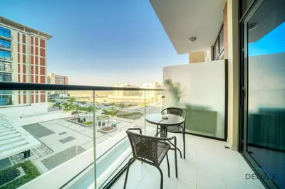 a balcony with a table and chairs and a view of a city at Lively Studio at DAMAC Celestia A Dubai South by Deluxe Holiday Homes in Dubai