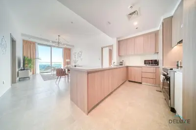 a kitchen with wooden cabinets and a kitchen island with a view at Cosmopolitan 2BR at Stella Maris Dubai Marina by Deluxe Holiday Homes in Dubai