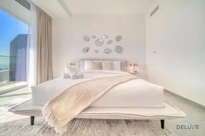 a white bedroom with a large bed with a blanket on it at Cosmopolitan 2BR at Stella Maris Dubai Marina by Deluxe Holiday Homes in Dubai