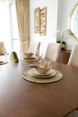 a wooden table with two plates and a wine glass at INA Homes-Residences Tower 7 Full Burj Khalifa & Fountain Views in Dubai