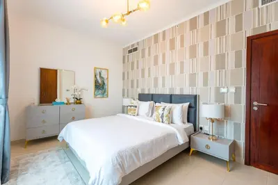 a bedroom with a large bed with white sheets and pillows at INA Homes-Residences Tower 7 Full Burj Khalifa & Fountain Views in Dubai