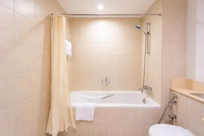 a bathroom with a tub and a toilet and a sink at INA Homes-Residences Tower 7 Full Burj Khalifa & Fountain Views in Dubai