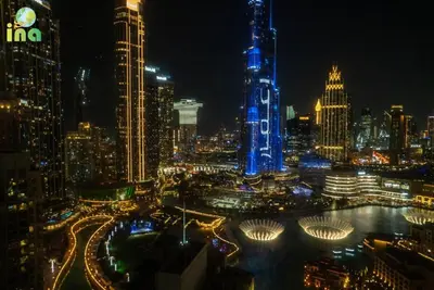 a view of a city at night with blue lights at INA Homes-Residences Tower 7 Full Burj Khalifa & Fountain Views in Dubai