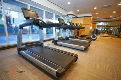 a gym with three tread machines in a room at Modern Spacious 2BR Canal View -Business Bay in Dubai