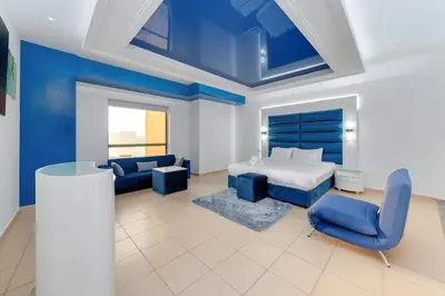 a bedroom with a bed and a blue accent wall at Elan Rimal Suites JBR Beach Sea View in Dubai