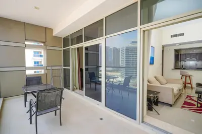a living room with a couch and a table at Unique 1BR Apartment in Sport City in Dubai