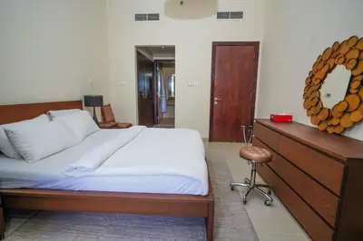 a bedroom with a bed and a mirror and a stool at Unique 1BR Apartment in Sport City in Dubai