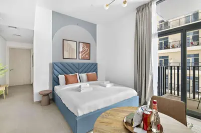 a bedroom with a bed and a table in a room at Silkhaus brand new studio in Belgravia Heights, JVC in Dubai