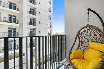 a swing chair on a balcony with a building at Silkhaus brand new studio in Belgravia Heights, JVC in Dubai