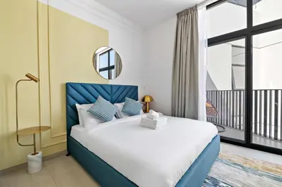 a bedroom with a large bed and a large window at Silkhaus modern studio in the heart of vibrant JVC in Dubai