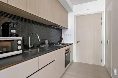 a kitchen with a sink and a microwave at Silkhaus modern studio in the heart of vibrant JVC in Dubai