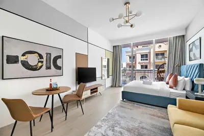 a hotel room with a bed and a table and chairs at Silkhaus new stylish studio in JVC Luma21 in Dubai