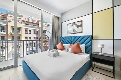 a bedroom with a large bed and a balcony at Silkhaus new stylish studio in JVC Luma21 in Dubai