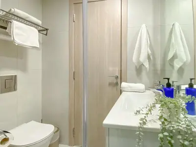 a bathroom with a toilet and a sink and a shower at Trophy - Urban Escape Suite in Dubai