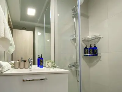 a bathroom with a shower and a sink at Trophy - Urban Escape Suite in Dubai