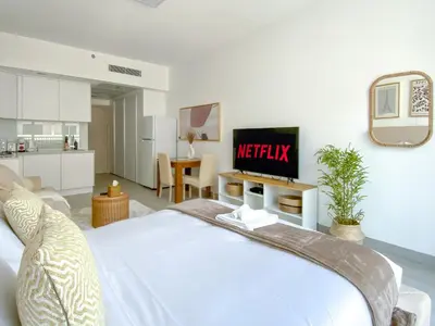 a bedroom with a bed with a television on a wall at Trophy - Urban Escape Suite in Dubai