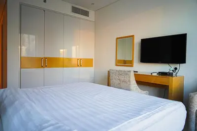 a bedroom with a bed and a desk and a television at Al Ashrafia Saray Magnificent 3BR Canal Views in Dubai